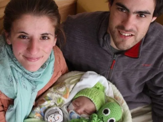 Mamá y papá sonrien junto a su bebé al ser dado de alta